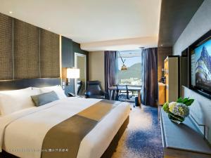 una camera d'albergo con un grande letto e una TV di Royal Plaza Hotel a Hong Kong