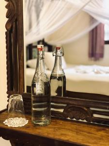 two bottles on a table in front of a mirror at Caravan Serai Amour in Stone Town