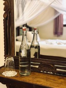 two bottles on a table in front of a mirror at Caravan Serai Amour in Stone Town +20 photos