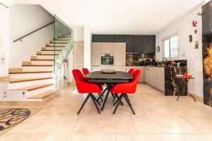 een keuken en eetkamer met een tafel en rode stoelen bij Villa en Bord de Mer in Saint-Raphaël