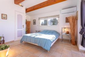 a bedroom with a bed with a blue comforter at Villa en Bord de Mer in Saint-Raphaël