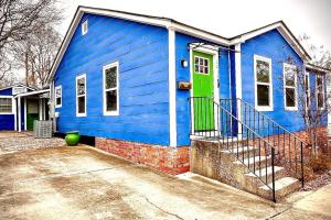 uma casa azul com uma porta verde numa rua em Cozy 2 King 2 Twin Cottage em Hattiesburg