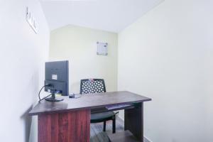 a desk with a computer on it with a chair at Liberty Apartments in Chakkarakkal