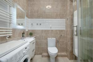 a bathroom with a toilet and a sink and a shower at White and Grey Studio with Balcony in Międzyzdroje SeaView by Rent like home in Międzyzdroje