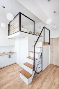 a staircase in a living room with white walls and wooden floors at Warm and light Loft near Vilnius centre in Vilnius