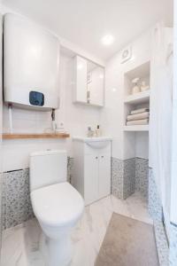 a white bathroom with a toilet and a sink at Warm and light Loft near Vilnius centre in Vilnius