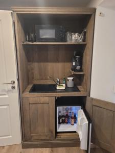 una pequeña cocina con fregadero y microondas en Landgasthaus Krimpenfort en Lohne