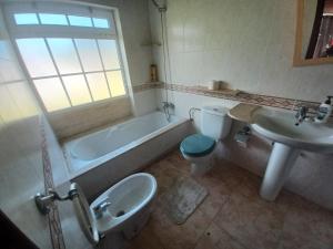 uma casa de banho com uma banheira, um WC e um lavatório. em Alojamientos O Camiño em Sigüeiro