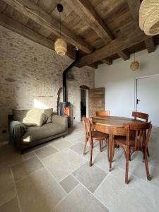 - un salon avec une table et un canapé dans l'établissement Appartement dans une vieille ferme bugiste, à Ceyzérieu