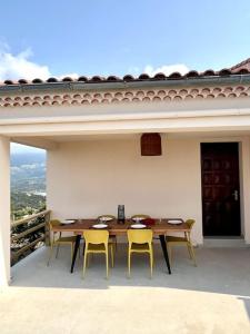 einen Tisch und Stühle auf einer Terrasse mit Aussicht in der Unterkunft Belle villa piscine vue mer in Santa-Reparata-di-Balagna