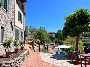 a house with a brick walkway next to a pool at Vicinato Homestead in Molazzana