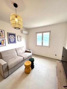 ein Wohnzimmer mit einem Sofa und einem TV in der Unterkunft Belle villa piscine vue mer in Santa-Reparata-di-Balagna