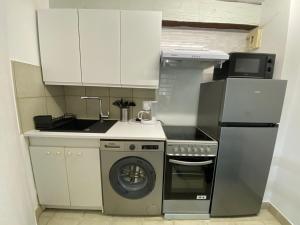 a small kitchen with a stove and a dishwasher at Villa calme, terrasse, climatisée, près d'Obalia, proche mer, parking inclus, classée 3 étoiles - FR-1-503-174 in Balaruc-les-Bains