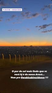 een poster van een hek met een zonsondergang op de achtergrond bij Wabisabi Residence in Araxá