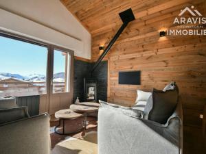 a living room with wooden walls and chairs and a tv at Appartement Le Grand-Bornand, 3 pièces, 6 personnes - FR-1-391-182 in Le Grand-Bornand