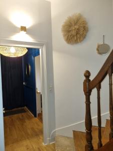 un couloir avec un escalier doté d'une porte bleue dans l'établissement Maison de charme - accès autonome, à Orléans