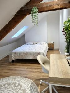 - une chambre mansardée avec 2 lits et une table dans l'établissement Maison de charme - accès autonome, à Orléans