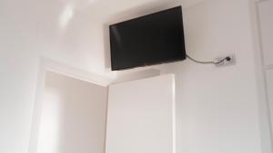 シッチェスにあるApto 1ª LÍNEA DE MAR con VISTAS a Sitgesの白いキャビネットの上に薄型テレビが備わります。