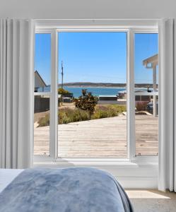 een slaapkamer met een groot raam met uitzicht op de oceaan bij Magnolia in Emu Bay
