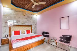a bedroom with a bed and chairs in a room at OYO Hotel Grand City in Chandīgarh