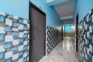 a corridor with a door and a wall of tiles at OYO Maa Home Stays 5 in Bhubaneshwar