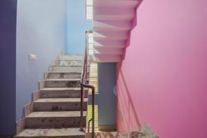 a stairway with a pink wall and a stair railing at OYO Maa Home Stays 5 in Bhubaneshwar