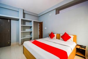 a bedroom with a large bed with red pillows at OYO Maa Home Stays 5 in Bhubaneshwar
