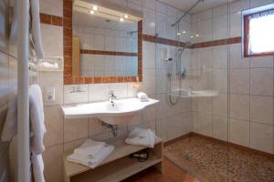 ein Bad mit einem Waschbecken und einer Dusche in der Unterkunft Hotel Gasthof Obermair in Fieberbrunn