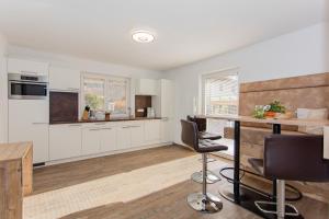 a kitchen with white cabinets and a table and chairs at Holiday Home Hettlerhof in Maishofen +10 photos