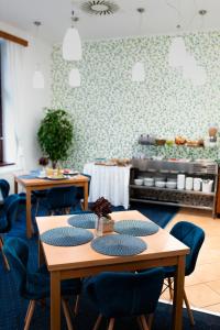 a dining room with tables and blue chairs at Hotel Apollon in Litoměřice