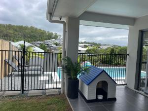 domek dla psów z niebieskim dachem na balkonie w obiekcie Upper Coomera Castle 1 w mieście Gold Coast