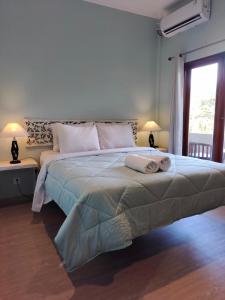 a bedroom with a large bed with a large window at Su's Cottages Legian in Legian