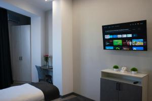 a bedroom with a bed and a tv on the wall at Tengri Hotel in Aktau