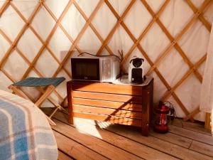a room with a tv on a table in a yurt at Yourte et son bain nordique in Fréchet-Aure