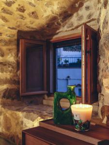 un jarrón verde sentado en una mesa junto a una ventana en La Grotte, en Corbara