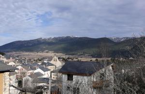 a town with a mountain in the background with houses at Appartement avec vue et jardin in Formiguères