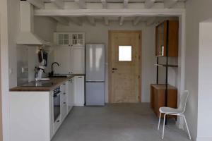 a kitchen with a refrigerator and a chair in it at Appartement avec vue et jardin in Formiguères