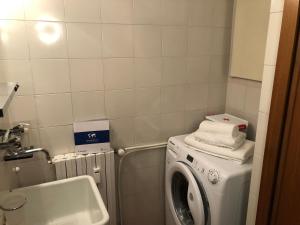 a bathroom with a washing machine and a sink at House Edelweiss by Holiday World in La Thuile