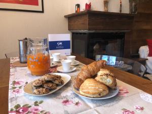 una mesa con dos platos de pan y una bebida en House Edelweiss by Holiday World en La Thuile