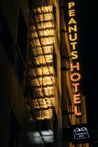 un cartello sul lato di un edificio di notte di ピーナッツホテル/PEANUTS HOTEL a Kobe