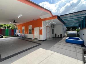 an outdoor patio with an orange and white building at Agro Village Stay in Tapah
