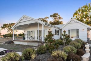 een wit huis met een veranda bij Magnolia in Emu Bay