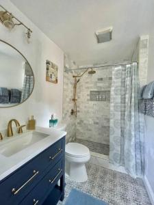 Un baño con lavabo, inodoro y ducha. en New, Modern, 3 bed/3 bath Apt, 10 miles to DC!, en Falls Church