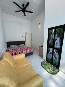 Agro Village Stay في Tapah: غرفة معيشة مع أريكة وسرير