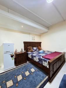 a bedroom with a large bed and a refrigerator at King Bed "STUDIO ROOM"-Khalidiya Abudhabi in Abu Dhabi