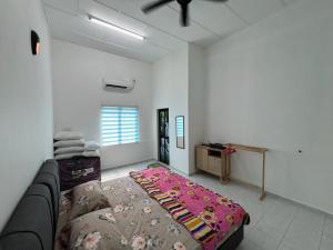 een woonkamer met een bank en een bed bij Agro Village Stay in Tapah