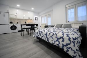 a bedroom with a bed and a kitchen and a table at APARTAMENTOS LUDOVICO in Béjar