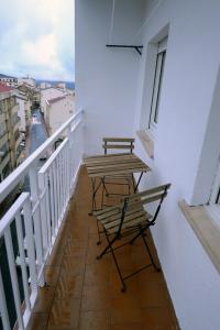 un balcón con 2 sillas y una mesa. en APARTAMENTOS LUDOVICO, en Béjar