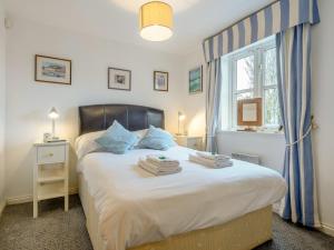 a bedroom with a bed with two towels on it at 3 Bed in Brixham BX050 in Galmpton-on-the-Dart