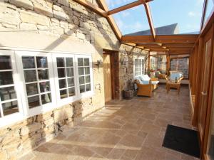 an outdoor patio with a stone wall and a glass roof at 3 Bed in Northumberland National Park CN043 in Alwinton